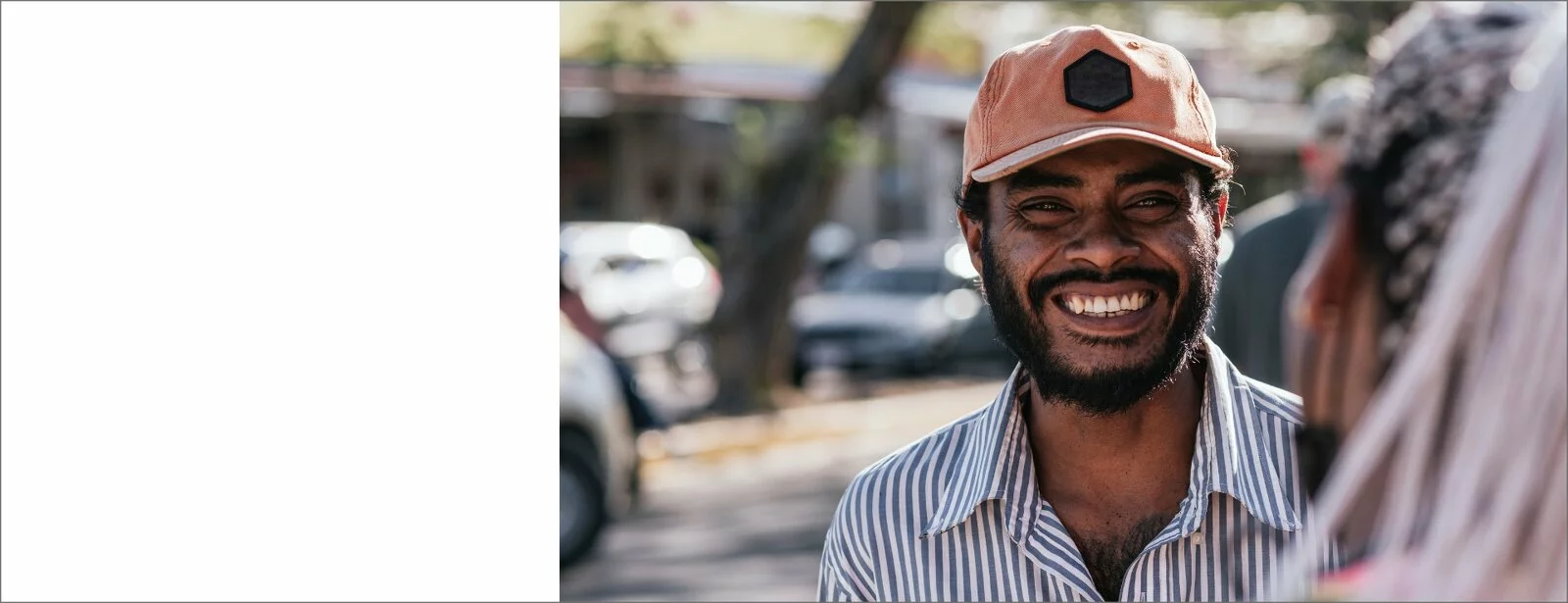 Young, Afro Latino man smiles into camera