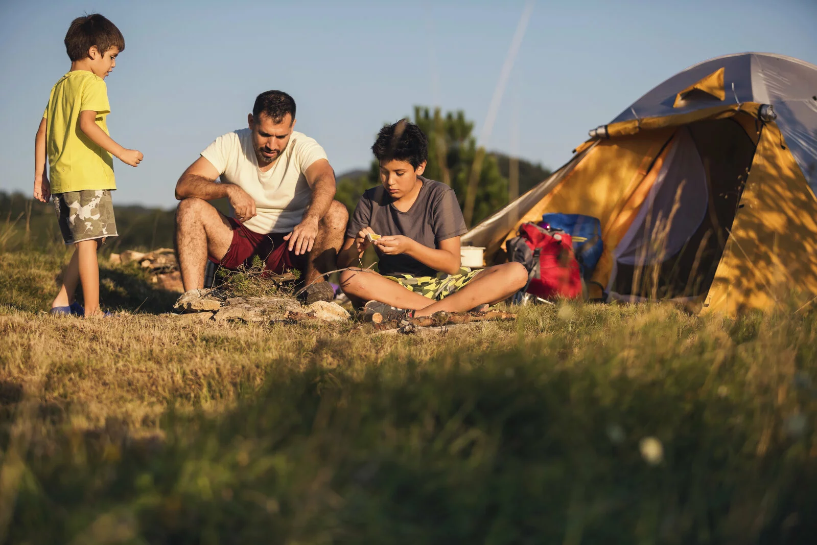 Father and two sons camping on the mountain